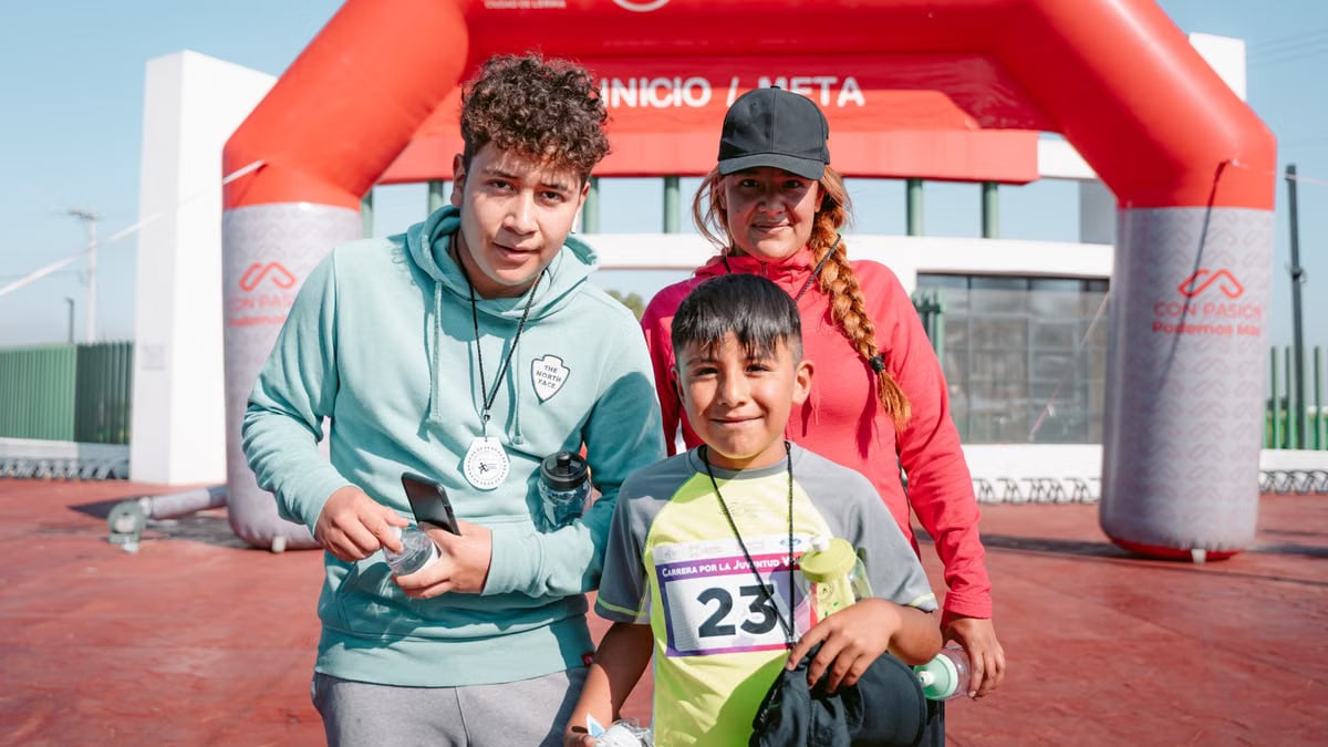Family posing happily at the race finish line during a sunny outdoor event.